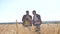 Teamwork smart farming slow motion video. two farmers work in wheat field. farmers explore are studying. man with