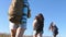 Teamwork travelers. travelers go with backpacks through meadow. mom and daughters, a little baby travel across field