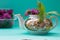 Teapot with clover, garden mint, box with fresh red clover on g