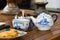 Teapot and a cup with sugar and cookies on a rustic coffee table, day light, indoors