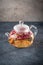 Teapot with detox drink from flower buds dry red pink rose tea with drops of condensate from hot water steam