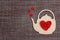 Teapot symbol with red hearts on sackcloth background. Flat lay, top view