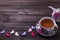 Teapot tea cup with hearts on brown wooden table.