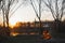 Teapot with tea hangs over the fire on the riverbank sunset