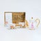 Teapot, two teacups, and a golden tray on a white background and surface
