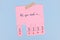 Tear off stub note with text `All you need is love` on pink paper