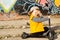 Tearful young boy sitting on his scooter