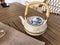 Teatime, Wooden tray with teapot, cups of natural chamomile tea and flowers on table.