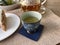 Teatime, Wooden tray with teapot, cups of natural chamomile tea and flowers on table.