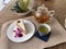 Teatime, Wooden tray with teapot, cups of natural chamomile tea and flowers on table.