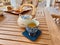 Teatime, Wooden tray with teapot, cups of natural chamomile tea and flowers on table.