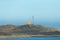 Technical building and metal tower on a hill on the coast. Iceland fjords