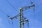Technical picture of a three-cable medium voltage line. Tutorial. School material. Object on the background of a blue sky with clo