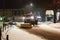 A technical service car with a large bulldozer cleans the city roads from the snow and sprinkles with sand. Unlocking the passage