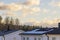 Technical view of villa roof equipped with solar panels against background of blue sky with white clouds.