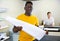 Technician african american working of printing house with stack of notebooks in her hands