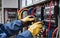 A technician carefully examines voltage levels at the circuit breaker terminal and checks the cable wiring in the main power