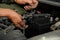 Technician changing car battery in auto repair garage