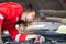 Technician checking modern car at garage, Young caucasian car mechanic standing by vehicle engine area with hood open, Car repair