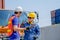 Technician and co-worker look happy during work in cargo containers area with one shows thumbs up action