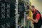 A technician connects fiber optic wires to a central router. A man works in a server room. An engineer serves computer equipment