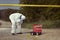 Technician Criminologist photographing tire print left in dust of field way