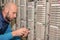 Technician cuts a telephone wire near a patch cross panel. Man works with pliers in the server room of an analog telephone