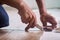 A technician is cutting luxury vinyl floor tiles with a cutter to lay the floor before placing it on the leveling foam