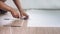 A technician is cutting luxury vinyl floor tiles with a cutter to lay the floor before placing it on the leveling foam