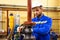 Technician employee opens gate valve on industrial pipeline