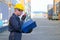 Technician or engineer with blue uniform and yellow helmet use walkie-talkie to contact with co-worker in cargo container shipping