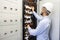 Technician engineer in datacenter. Network technician connecting fiber optic at server room.