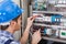 Technician examining fusebox with multimeter probe