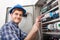 Technician examining fusebox with multimeter probe