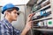 Technician examining fusebox with multimeter probe