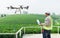 .Technician farmer use wifi computer control agriculture drone fly to sprayed fertilizer on the tea fields