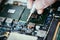 Technician is fixing a computer circuit board, hand and screwdriver