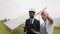 Technician and inspector standing among solar plant. Indian engineer in yellow hardhat and safety glasses holding