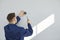 Technician installing modern surveillance CCTV dome camera on wall inside the house