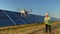 Technician and investor using infrared drone technology to inspect solar panels and wind turbines in solar cell farm