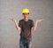 Technician man ware yellow helmet with dark grey T-shirt and denim jeans standing and palms facing up of two hands.