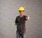 Technician man ware yellow helmet with dark grey T-shirt and denim jeans standing and thumbs up.