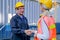 Technician man and woman shake hand together in front of cargo container with concept of successful in shipping business