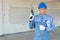 Technician or Mechanic wear Blue Hardhat and Protection Suit hold Drill and Blueprint ready to Serve Customer as Home Maintenance