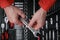 Technician mechanic wearing red clothes holding chrome socket wrench tool on toolbox background for repair maintenance service