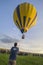 Technician raising hot air balloon over crowd