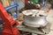 Technician removing rubber from car wheel disc & balancing tyre on balancer in auto repair garage