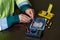 A technician repairs the digital Board and measures the voltage. Computer and mobile device repair concept.