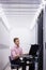 Technician sitting on swivel chair using laptop to diagnose servers