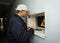 Technician stands near window of the radiation control post handing dose rate meters for checking. Chernobyl Nuclear